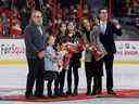 L'ancien grand sénateur d'Ottawa Wade Redden (à l'extrême droite) assiste à son intronisation à la Ring of Honor depuis le centre de la patinoire avec sa femme, Danica (deuxième à partir de la droite), leurs trois filles, Lenny, Harper et Ryann, et son père, Gord Redden, au Centre Canadian Tire lundi soir.