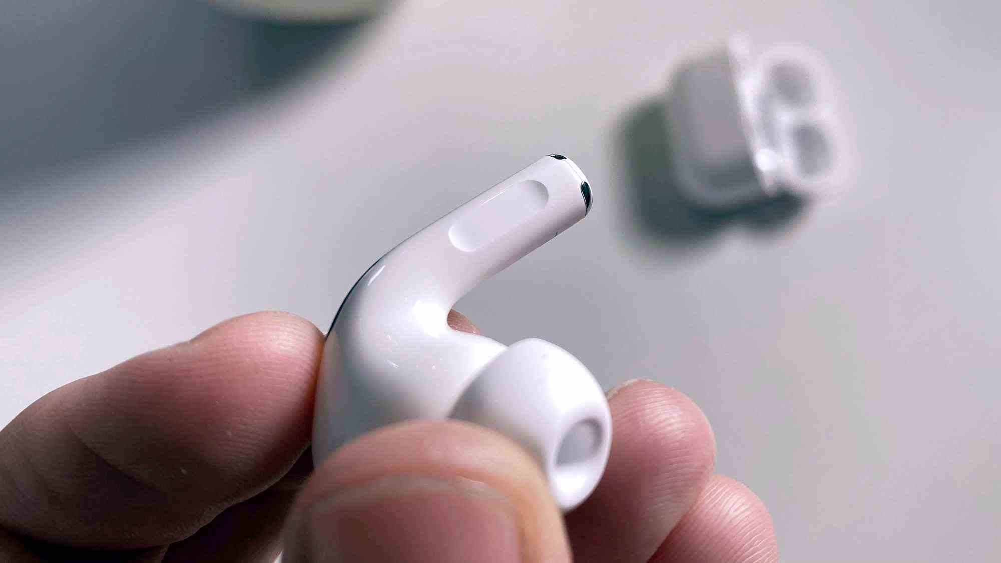 Une personne tenant l'un des écouteurs AirPods Pro dans ses doigts.