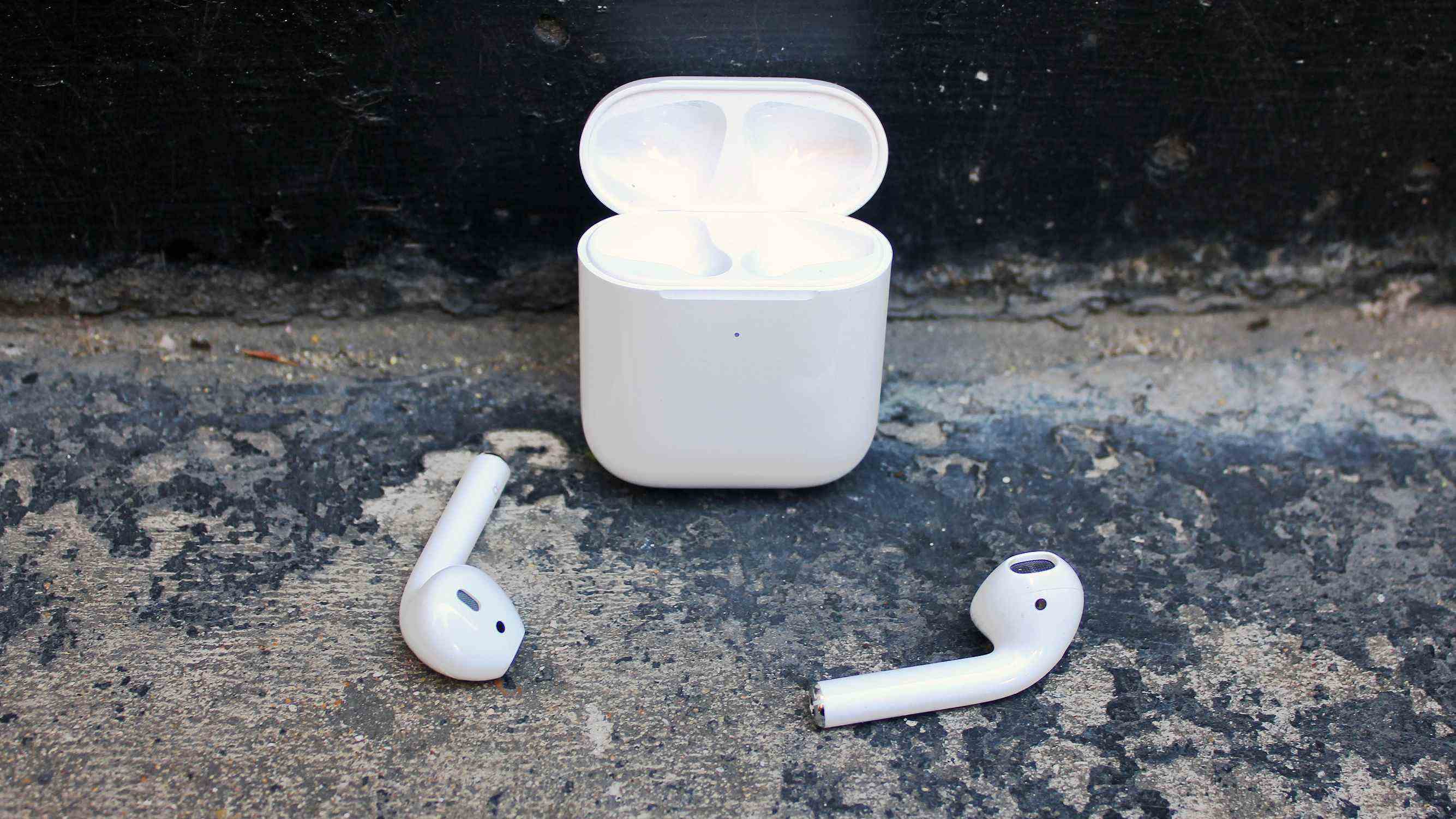 Les bourgeons Apple Airpods 2019 disposés devant leur étui de chargement.