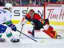 14 décembre 2022 ;  Calgary, Alberta, CAN ;  Le gardien de but des Flames de Calgary Jacob Markstrom (25) fait une sauvegarde contre l'ailier droit des Canucks de Vancouver Conor Garland (8) pendant la période de prolongation au Scotiabank Saddledome.  Crédit obligatoire : Sergei Belski - USA TODAY Sports