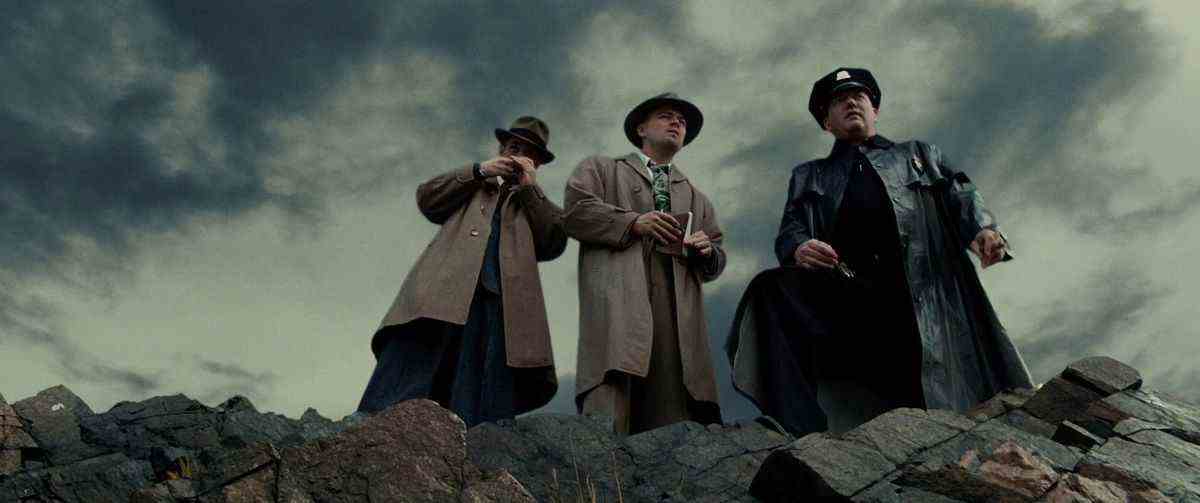 Trois détectives regardent une falaise à Shutter Island