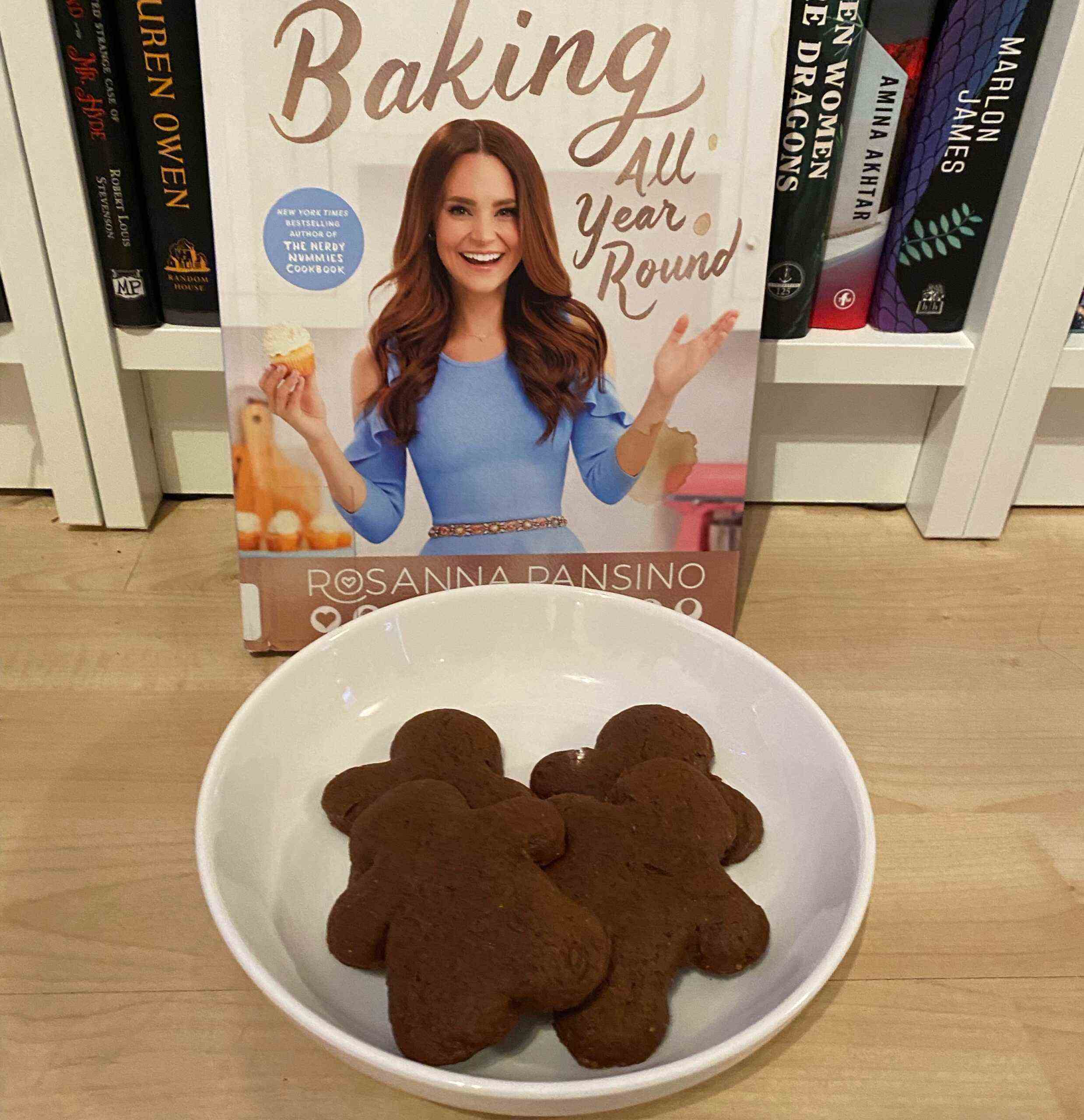 Une assiette de biscuits au pain d'épice devant le livre de cuisine Baking All Year Round