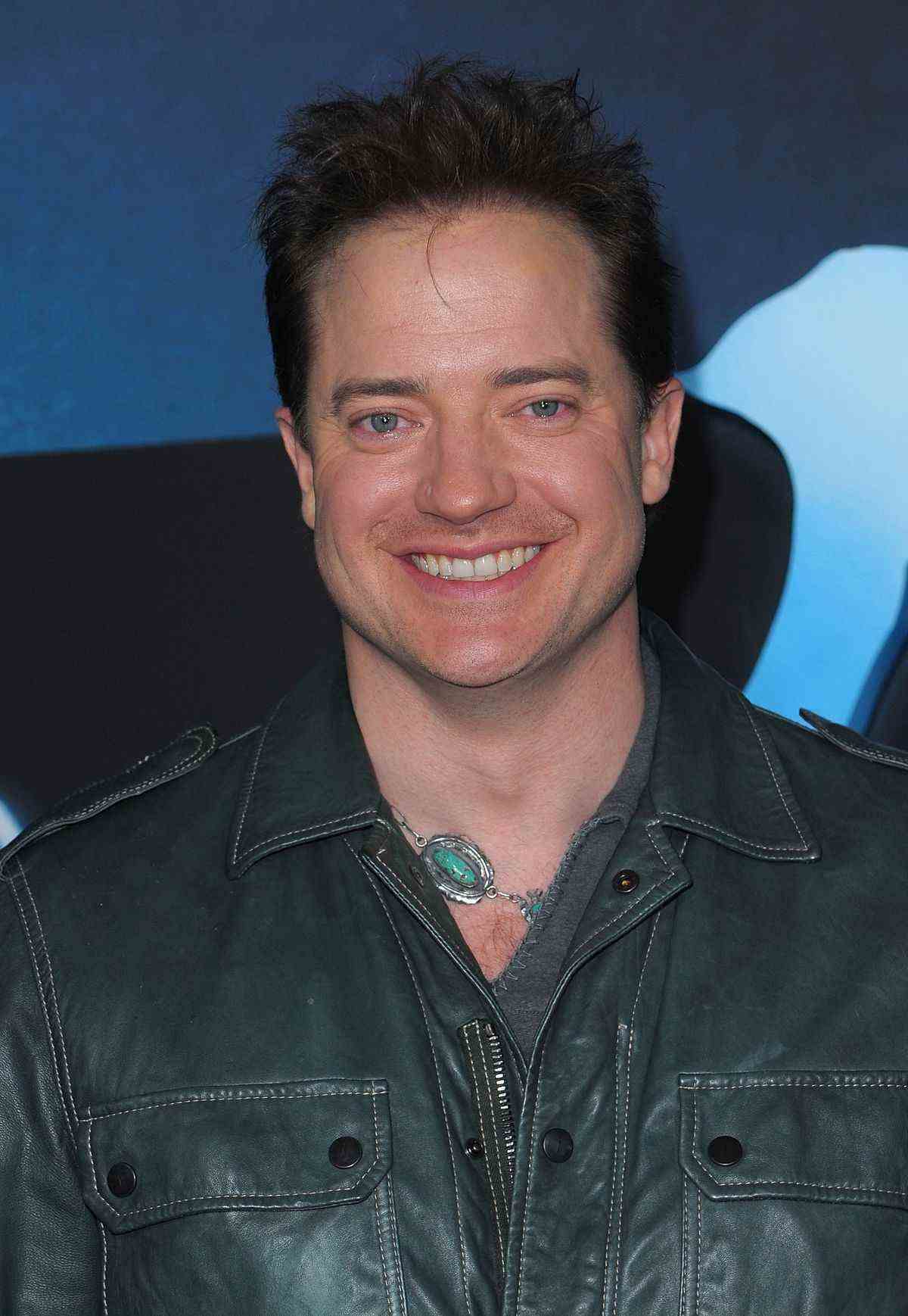 Brendan Fraser portant un gros collier vert et une veste en cuir lors de la première d'Avatar