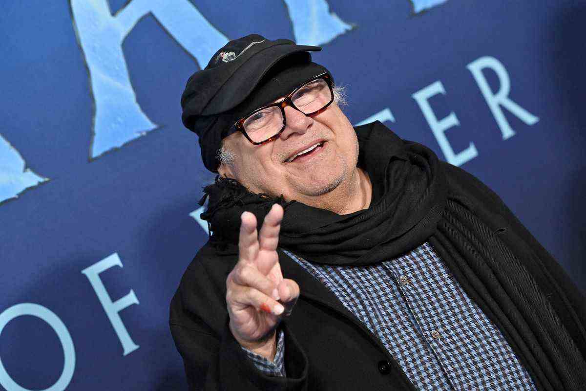 Danny DeVito fait un signe de paix sur le tapis bleu de la première d'Avatar : Way of Water