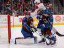 Le centre des Canadiens Kirby Dach (77) tente de dévier la rondelle contre le gardien de but de l'Avalanche du Colorado Alexandar Georgiev (40) alors que le centre Alex Newhook (18) défend en première période au Ball Arena de Denver le 21 décembre 2022.