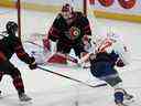 Le gardien de but des Sénateurs d'Ottawa Cam Talbot effectue un arrêt de la jambière sur un tir du centre des Capitals de Washington Evgeny Kuznetsov (à droite) sous la pression du défenseur des Sénateurs Nick Holden.