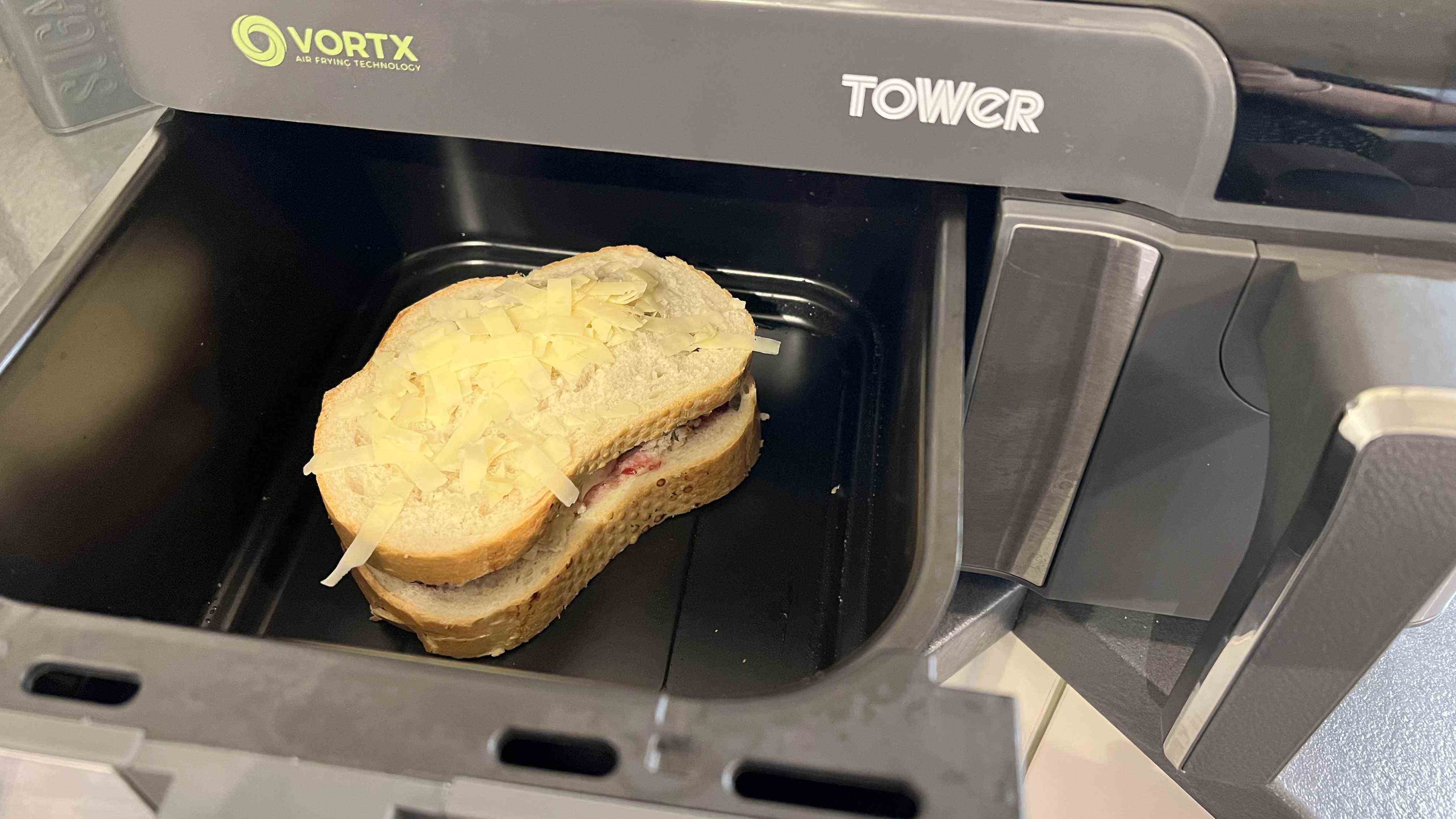 Toastie restant de Noël avec du fromage sur le dessus dans une friteuse à air