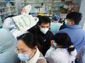 Les gens font la queue pour acheter des kits de test d'antigène COVID-19 dans une pharmacie à Hangzhou, province du Zhejiang, Chine, le 19 décembre.