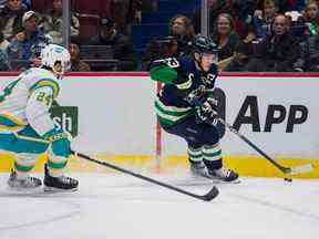 Bo Horvat (53 ans) dépasse le défenseur des Sharks Jaycob Megna (24 ans) en première période au Rogers Arena