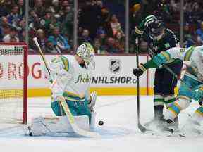 Le gardien des Sharks James Reimer, à gauche, arrête Elias Pettersson lors de la première période au Rogers Arena mardi.