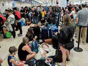 Les passagers des compagnies aériennes Sunwing font la queue pour l'enregistrement à l'aéroport international de Cancun après que de nombreux vols vers le Canada ont été annulés en raison des conditions météorologiques hivernales rigoureuses dans diverses régions du pays, le 27 décembre 2022.