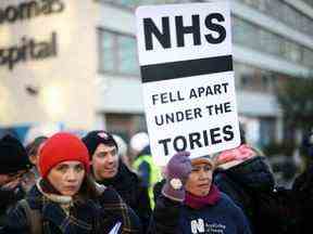 Une infirmière du NHS tient une pancarte pendant une grève, en raison d'un différend avec le gouvernement sur le salaire, devant l'hôpital St Thomas de Londres, le 15 décembre.