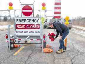 Tim Ferguson dépose des fleurs sur les lieux pendant que la police enquête sur le meurtre d'un agent de la Police provinciale de l'Ontario sur Indian Line à Objiwa Road à l'ouest de Hagersville le mercredi 28 décembre 2022. (Derek Ruttan/The London Free Press)