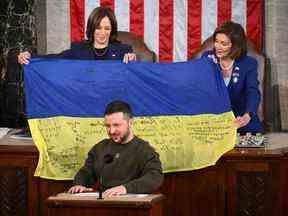 Le président ukrainien Volodymyr Zelensky s'adresse au Congrès américain en tant que vice-président américain Kamala Harris, à gauche, et la présidente de la Chambre Nancy Pelosi tiennent un drapeau que leur a remis le président ukrainien Volodymyr Zelenskyy alors qu'il s'adresse au Congrès le 21 décembre 2022. Mandel Ngan / AFP