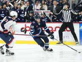 L'attaquant des Jets de Winnipeg Pierre-Luc Dubois (80 ans) tente de patiner autour du défenseur des Blue Jackets de Columbus Jake Christiansen (23 ans au cours de la deuxième période au Canada Life Centre à Winnipeg le vendredi 2 décembre 2022.