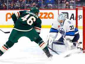 Le défenseur du Wild du Minnesota Jared Spurgeon (46 ans) marque sur le gardien des Jets de Winnipeg Connor Hellebuyck (37 ans) en première période au Canada Life Centre à Winnipeg le mardi 27 décembre 2022.