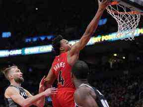 L'attaquant des Raptors de Toronto Scottie Barnes (4) conduit au panier au-dessus de l'attaquant des Sacramento Kings Domantas Sabonis (10) au cours du quatrième trimestre à la Scotiabank Arena.