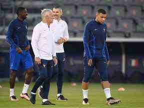 L'entraîneur français Didier Deschamps (C) s'entretient avec l'attaquant français #10 Kylian Mbappe lors d'une séance d'entraînement au centre d'entraînement Al Sadd SC à Doha le 17 décembre 2022, à la veille de la finale de la Coupe du monde de football Qatar 2022 entre l'Argentine et la France .