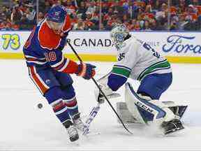 Le gardien de but des Canucks de Vancouver Thatcher Demko (35) fait un arrêt sur l'attaquant des Oilers d'Edmonton Derek Ryan (10) au cours de la troisième période à Rogers Place.