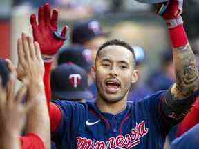 Carlos Correa, des Twins du Minnesota, à droite, est félicité après avoir frappé un coup de circuit en solo contre les Angels de Los Angeles lors de la première manche d'un match de baseball à Anaheim, en Californie, le samedi 13 août 2022.