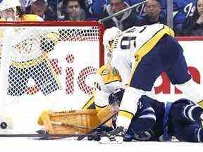 Un défenseur tombé des Jets de Winnipeg, Dylan DeMelo, marque sur le gardien de but des Predators de Nashville, Juuse Saros.  USA AUJOURD'HUI SPORTS