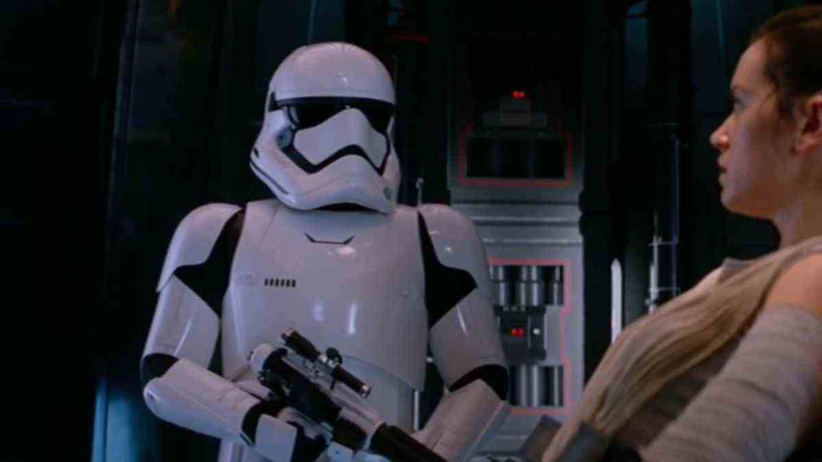 Daniel Craig wearing stormtrooper armor in front of Daisy Ridley in The Force Awakens