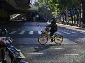 Des gens traversent une rue du quartier de Jing'an à Shanghai le 21 décembre 2022.