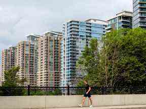 Un piéton passe devant des immeubles en copropriété dans le quartier de Liberty Village à Toronto.