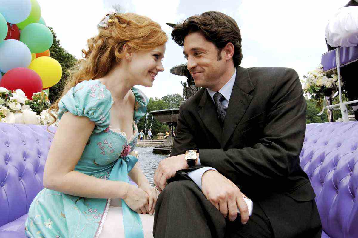 Live-action Disney Princess Giselle (Amy Adams) et l'amoureux Robert (Patrick Dempsey) sont assis en souriant, la tête jointe dans un autocar capitonné violet circulant dans un parc de New York dans Enchanted