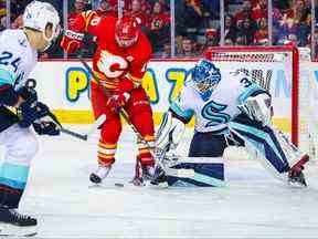 Le gardien de but du Seattle Kraken Joey Daccord fait un arrêt contre le centre des Flames de Calgary Jonathan Huberdeau au cours de la troisième période au Scotiabank Saddledome.