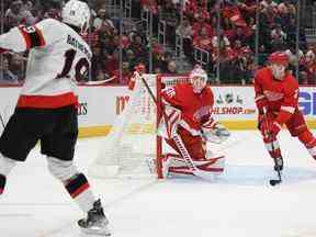 L'ailier droit des Sénateurs Drake Batherson tire la rondelle du gardien des Red Wings Ville Husso et dans la cage pour un but en première période du match de samedi à Détroit.