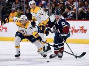 Le défenseur des Nashville Predators Jordan Gross et l'ailier gauche de l'Avalanche du Colorado Dryden Hunt se battent pour la rondelle en première période au Ball Arena.