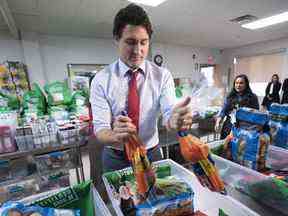 Le premier ministre Justin Trudeau charge des paniers de nourriture dans une banque alimentaire à Montréal, le 20 décembre 2022.