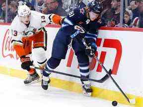 Le défenseur des Anaheim Ducks Simon Benoit (13) vérifie l'ailier gauche des Jets de Winnipeg Kyle Connor (81) en deuxième période au Canada Life Centre à Winnipeg le dimanche 4 décembre 2022.