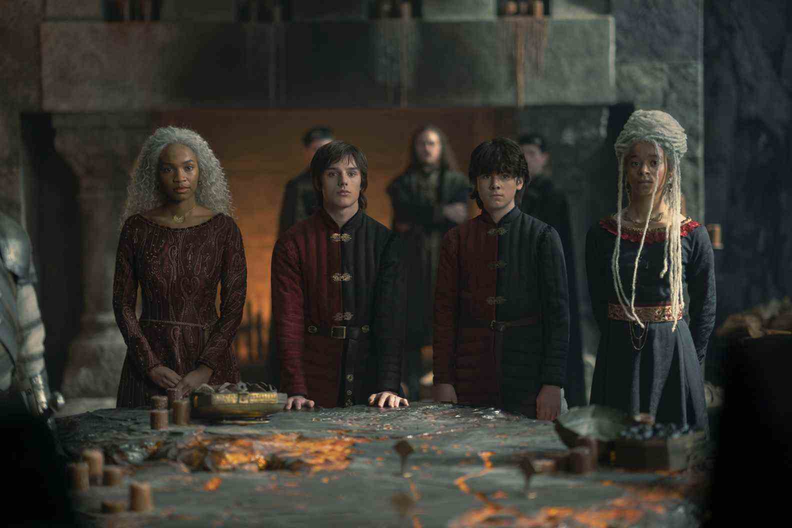 Baela Targaryen (Bethany Antonia), Jace Velaryon (Harry Collett), Lucerys Velaryon (Elliot Grihault), and Rhaena Targaryen (Phoebe Campbell) gather around the lit table at Dragonstone in House of the Dragon