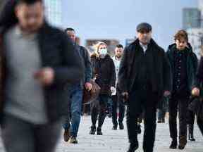 Les navetteurs traversent le pont de Londres pendant l'heure de pointe du matin dans le centre de Londres en 2020.