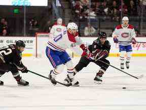 L'ailier droit des Canadiens Joel Armia déplace la rondelle devant le centre des Coyotes de l'Arizona Nick Schmaltz lors de la première période au Mullett Arena de Tempe, en Arizona, le 19 décembre 2022.