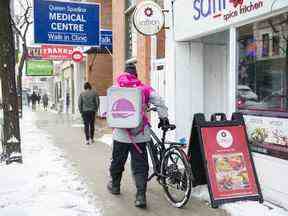 Un coursier Foodora récupère une commande à livrer dans un restaurant de Toronto.