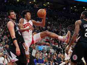 Scottie Barnes des Raptors arrive avec un ballon contre Ivica Zubac (40 ans) des LA Clippers et l'attaquant Kawhi Leonard lors de la première mi-temps à la Scotiabank Arena le mardi 27 décembre 2022.