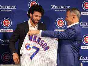 Le président Jed Hoyer des Chicago Cubs présente un maillot à Dansby Swanson lors de sa conférence de presse d'introduction au Wrigley Field le 21 décembre 2022 à Chicago.