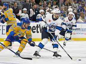 L'ailier gauche des Jets de Winnipeg Pierre-Luc Dubois contrôle la rondelle alors que le centre des Blues de St. Louis Brayden Schenn défend au Enterprise Center de St. Louis jeudi soir.  Jeff Curry/USA AUJOURD'HUI SPORTS