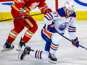 Connor McDavid des Oilers d'Edmonton après avoir reçu un coup sûr de Mackenzie Weegar des Flames de Calgary lors d'un match de hockey de la LNH au Scotiabank Saddledome de Calgary le mardi 27 décembre 2022.