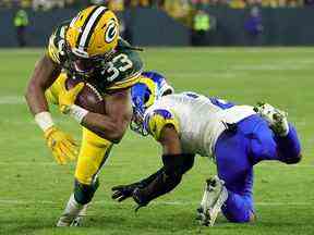 Aaron Jones des Packers de Green Bay évite un tacle de Troy Hill des Rams de Los Angeles au Lambeau Field le 19 décembre 2022 à Green Bay, Wisconsin.