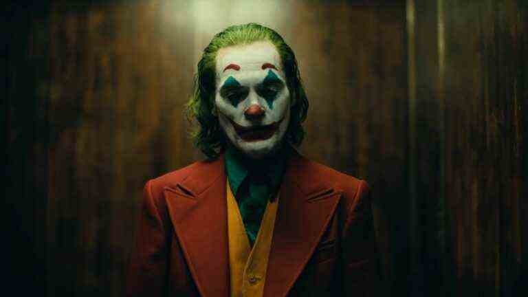 Joaquin Phoenix in full clown makeup standing in elevator during Joker