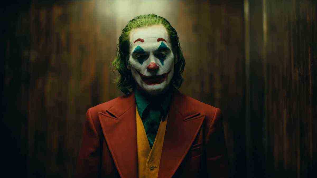 Joaquin Phoenix in full clown makeup standing in elevator during Joker