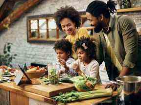 Heureuse famille afro-américaine préparant des aliments sains dans la cuisine.