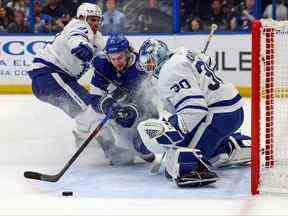 Anthony Cirelli du Lightning de Tampa Bay est contrôlé par John Tavares des Maple Leafs de Toronto alors qu'ils percutent Matt Murray au cours de la deuxième période du match à l'Amalie Arena le 3 décembre 2022 à Tampa, en Floride.