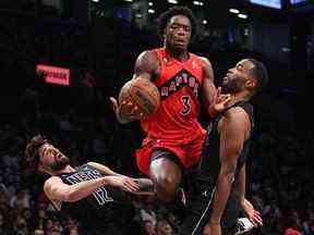 L'attaquant des Toronto Raptors OG Anunoby (3) tire une charge sur l'attaquant des Brooklyn Nets Joe Harris (12) et l'attaquant TJ Warren (1) vendredi au Barclays Center.