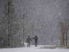 De fortes chutes de neige tombent alors qu'un homme court sur un sentier à Central Park à Burnaby, en Colombie-Britannique, le mardi 29 novembre 2022. Des avertissements de chute de neige, de tempête hivernale et d'écoulement arctique sont en vigueur pour la majeure partie de la Colombie-Britannique alors qu'une puissante tempête emballant des vents glacials se déplacent à travers la province.