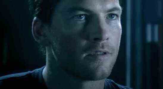 Sam Worthington looking forward with determination in a dark room in Avatar.